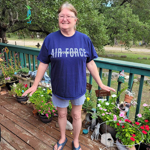 cute air force mom standing proudly show off her new graphic design tee in her garden