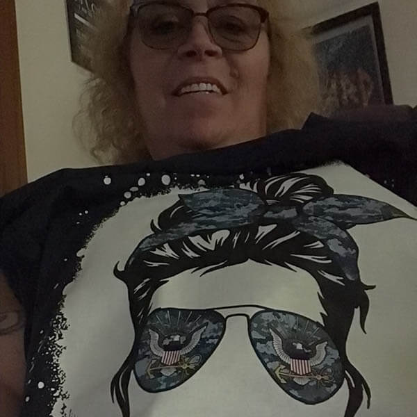 navy mom wearing a messy bun design t shirt from MotherProud while taking a selfie photo.jpg